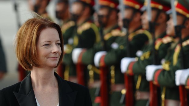 Prime Minister Julia Gillard is greeted by an honour guard as she arrives in Vientiane, Laos, for the Asia-Europe summit.