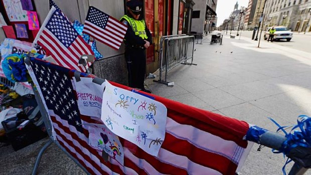 A police officer bows his head during a moment of silence near the Boston Marathon finish line.