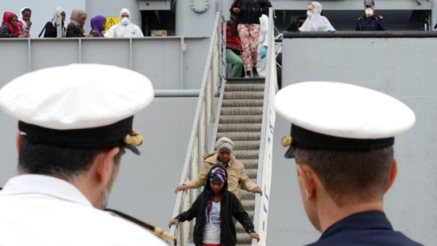 Migrants disembark from an Italian Navy ship in Sicily.