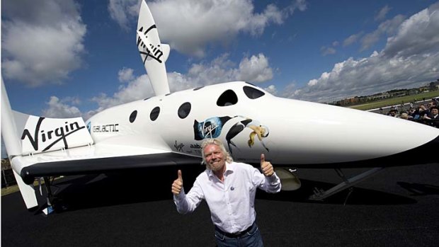 British billionaire Richard Branson poses in front of a model of Virgin Galactic's SpaceShipTwo at the Farnborough International Airshow. Branson hopes the first flight will happen next year.