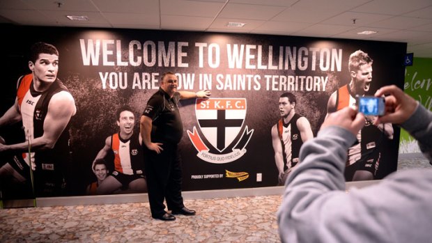 A Victorian man poses in front of a welcome poster at Wellington airport.