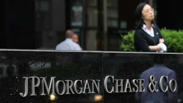 $2 billion trading blunder ... pedestrians walk past a sign outside of a JPMorgan Chase office in New York.