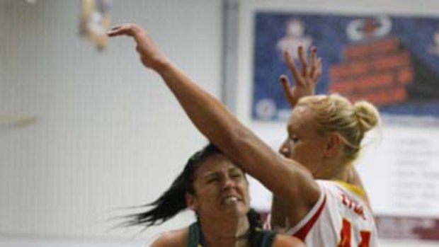Dandenong's Sam Woosnam typifies her side's mindset by barging past Adelaide's Augustina Zygaite.