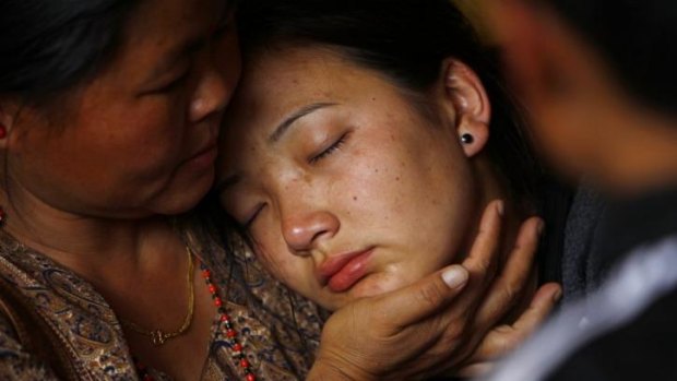 A woman cries as her father's body is brought to a Sherpa Monastery.