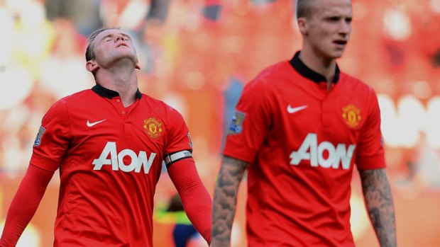 Defeated, deflated: Manchester United forward Wayne Rooney (L) reacts as he leaves the pitch with teammate Alexander Buttner.