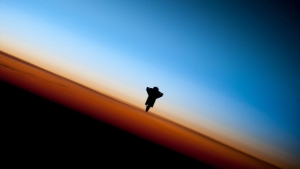 This image provided by NASA shows the silhouette of the space shuttle Endeavour in a very unique setting over Earth's colorful horizon photographed by an Expedition 22 crew member prior to STS-130 rendezvous and docking operations with the International Space Station Tuesday Feb. 9, 2010. (AP Photo/NASA)