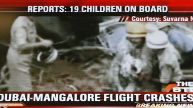Many dead ... this frame from television shows Indian rescue workers at the scene of an Air India aircraft which has crashed at Mangalore.