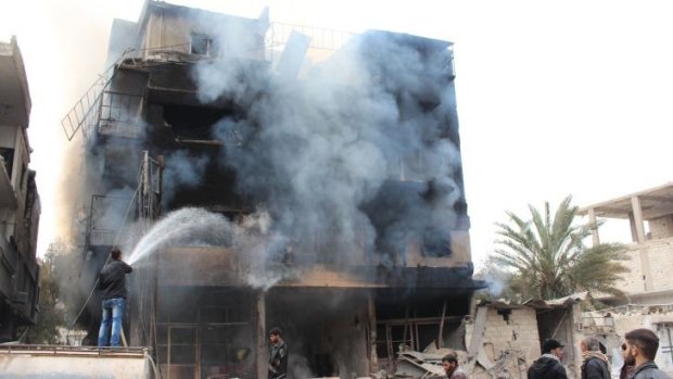 Men try to put out a fire in a building in the city of Daraya, southwest of the capital Damascus.