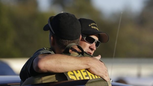 A pair of Placer County Deputy Sheriff's embrace after a suspect was arrested.
