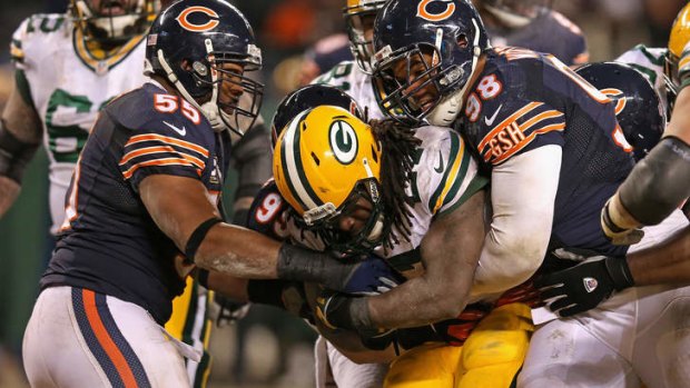 Eddie Lacy of the Green Bay Packers is hit by (L-R) Lance Briggs, Shea McClellin and Corey Wootton of the Chicago Bears.