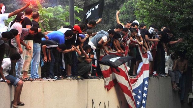 Anger in Egypt ... protesters tear down a flag at the US embassy in Cairo.