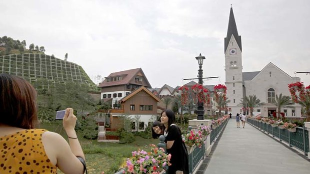 Chinese visitors take pictures at an European-style houses in Hallstatt See, a replica of the Austrian town of Hallstatt, in south China's Guangdong province.