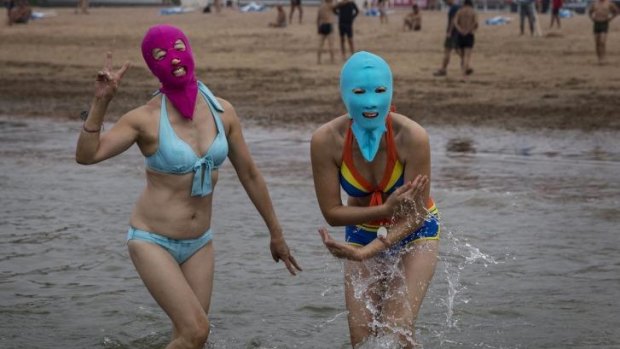 Chinese women wear facekinis as they walk in to the water to swim at the beach in the Yellow Sea in Qingdao, China.