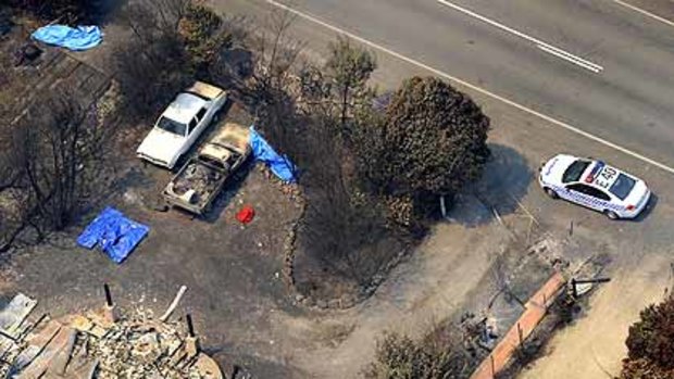 Bodies lie in front of a house that was razed to the ground on the Whittlesea-Yea Road.
