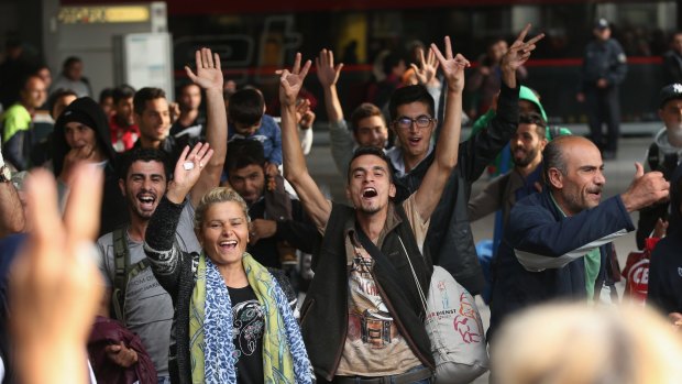 Migrants arriving on a train from Hungary react to the welcoming cheers of onlookers at Munich Hauptbahnhof main railway station on Saturday.