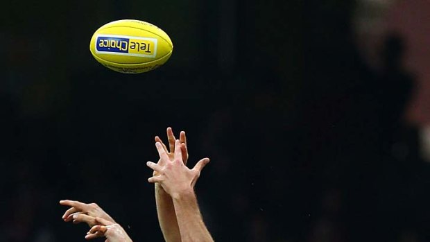 Ted Richards and Heath Grundy of the Swans compete for the ball against Hamish McIntosh of the Kangaroos.