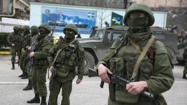 Occupation: Armed servicemen stand near Russian army vehicles in Crimea.