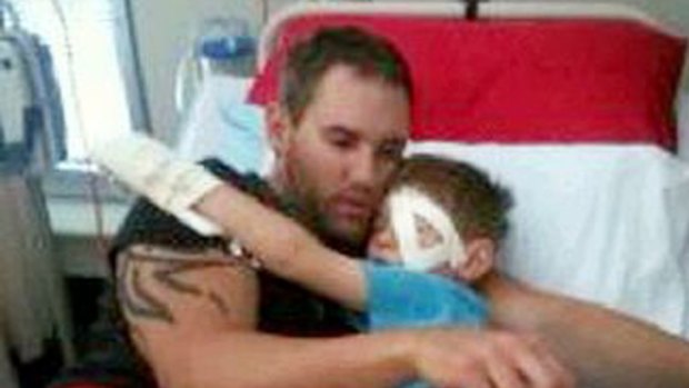 Toowoomba man Chris McInnes nurses his son Seth who was blinded in his left eye by a swooping magpie.