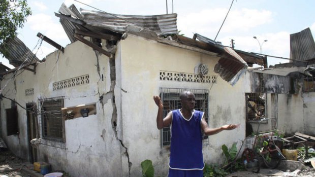 A man gestures infront of houses damaged after a series of explosions at a munitions depot in Brazzaville.