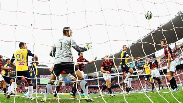 Patrick Zwaanswijk of the Mariners heads the ball past Wanderers goalkeeper Ante Covic to open his team's account in the A-League grand final.