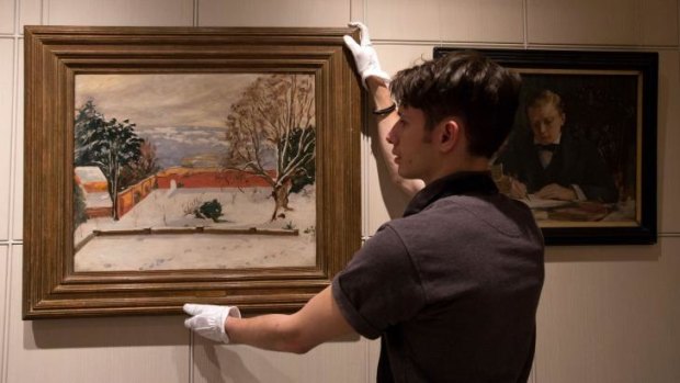 Record: A Sotheby's staff member with the Winston Churchill painting <i>The Weald of Kent Under Snow</i>.