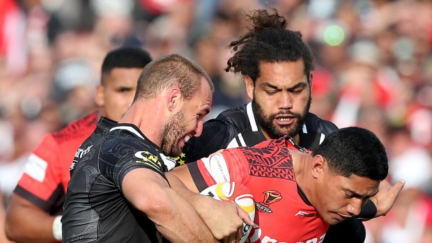 On the charge: Jason Taumalolo is tackled by Simon Mannering, left, and Adam Blair.