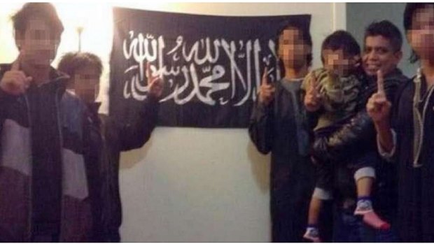 A photo Zulfikar Shariff posted on his Facebook page of himself with his children in front of a flag associated with the Islamist group Hizb ut-Tahrir.
