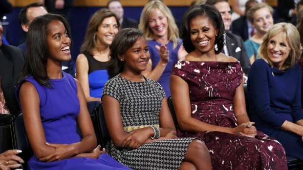 The President's daughters, Malia and Sasha, and first lady Michelle Obama smile as they listen to the Barack Obama accept the Democratic Party's nomination.