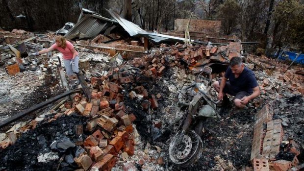 Paul and Karen Bousfield pick through the rubble of their home in Buena Vista Rd, Winmalee.