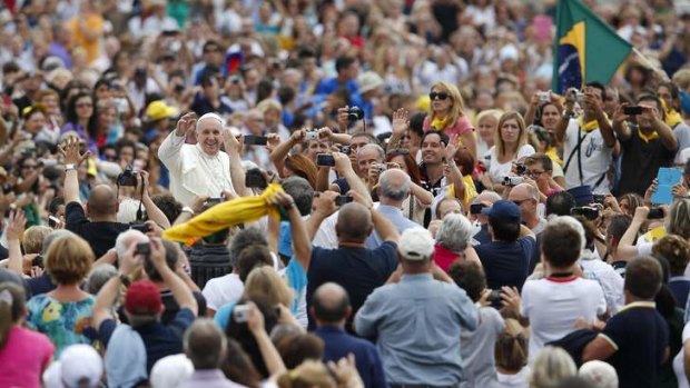 Man of the people: Pope Francis waves as he arrives to lead his Wednesday general audience in St Peter's square at the Vatican.