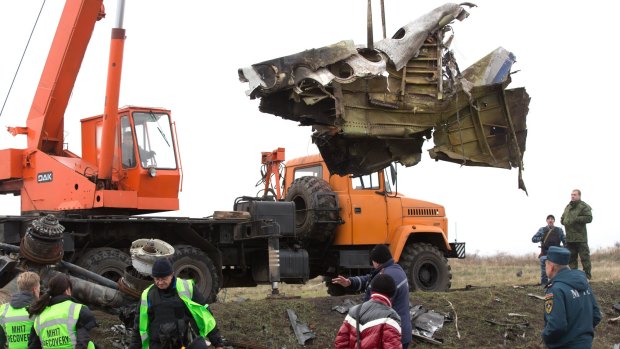 Investigators collect debris from the downed airliner, flight MH17, in the Ukraine last year.