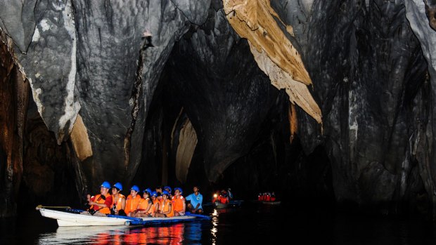 Tourists in a rowing boat enter the underground river in Puerto Princesa River National Park.