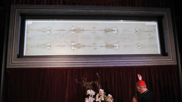 Sacred relic... Cardinal Severino Poletto stands before the Shroud of Turin at the Turin Cathedral.