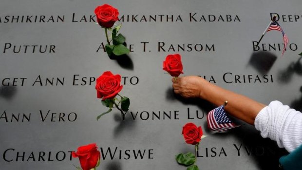 A woman places flowers in the inscribed names along the edge of the North Pool during memorial observances on the 13th anniversary of the Sept. 11 terror attacks on the World Trade Centre in New York.