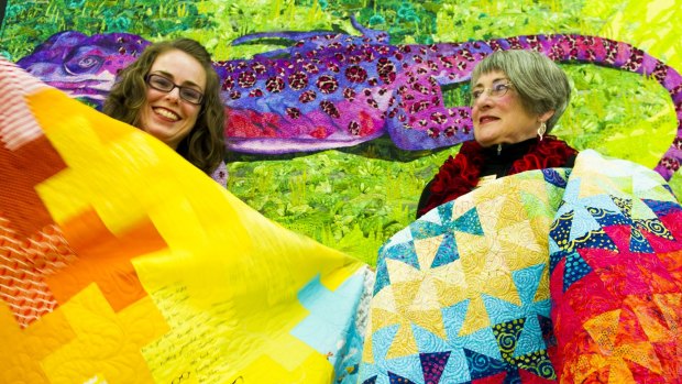 Canberra Quilters member Gemma Jackson, left, and president Helen Rose with some of the beautiful quilts.