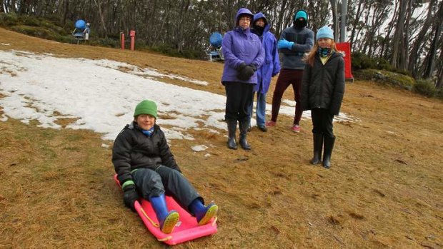After travelling from Adelaide, Tom Ricci (on toboggan) and his family found most of the snow had melted.