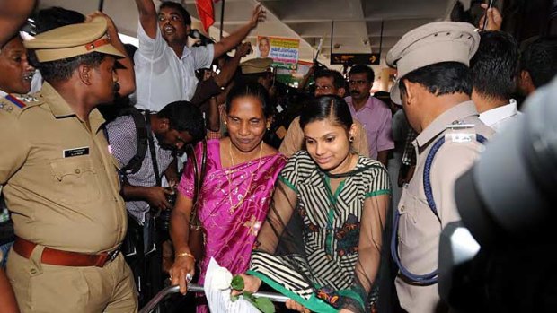 Greeted by tears and cheers: Indian nurses walk through crowds after arriving at Kochi airport in southern India.