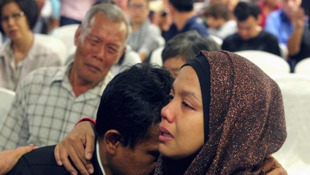 Long wait: Family members of those on board the missing Malaysia Airlines flight MH370 cry as they wait for more information.