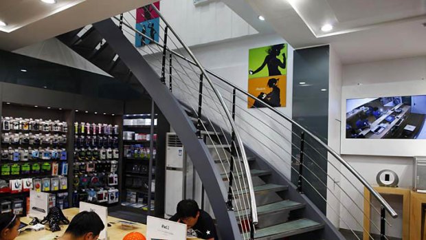 Customers test out electronic products in a fake Apple Store in Kunming, Yunnan province on July 22, 2011.