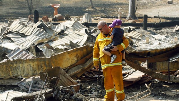 Firefighter Steve Nash with son Lachlan at their burnt house.
