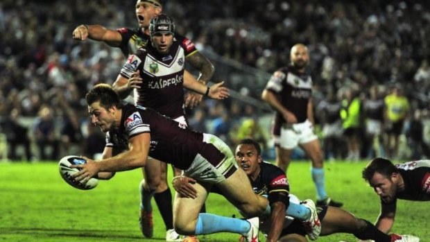 Centre of controversy: Kieran Foran goes over for Manly despite a strong claim for obstruction against Jamie Buhrer.