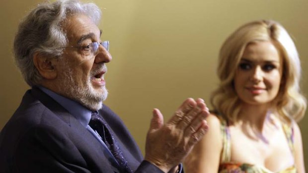 Spanish singer and conductor Placido Domingo, left, answers a question at a press conference as Welsh singer Katherine Jenkins listens.