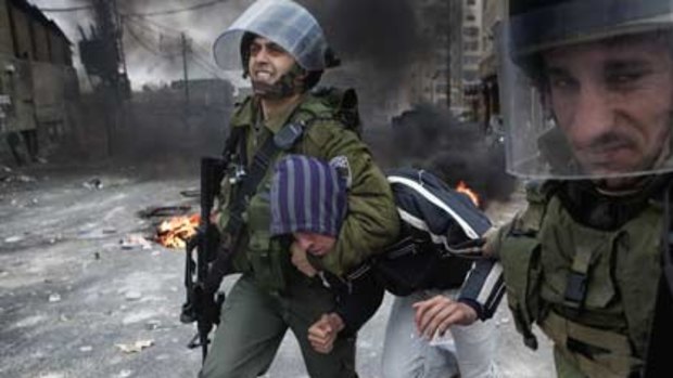 Israeli border policemen arrest a Palestinian youth during clashes in East Jerusalem Shafai camp on Tuesday.