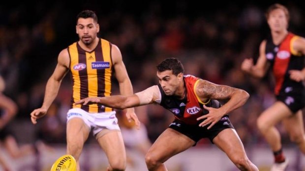 Essendon's Courtenay Dempsey and Hawthorn's Paul Puopolo watch the ball when the teams met in season 2013.