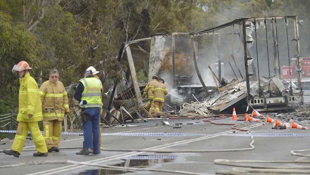 Police and firemen secure the scene of the fiery double-fatal crash near Stawell.