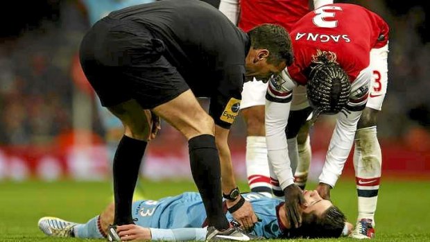 West Ham's Daniel Potts is checked by Arsenal's Bacary Sagna (R) and referee Andre Marriner after he was injured.