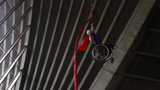 Steel will ... Paul Nunnari scales a ribbon suspended from the ceiling of the Sydney Opera House's southern foyer for the International Day of People with Disability.