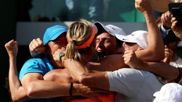 Celebrations: Sharapova is mobbed by her team.