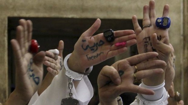 Women jailed for protesting in Egypt display slogans on their hands during their appeal hearing.