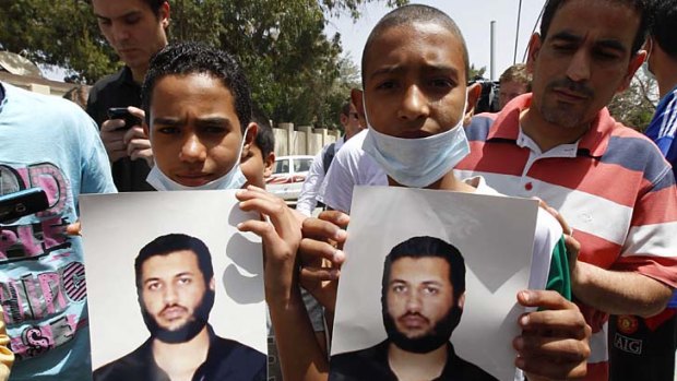 Young men hold pictures of Saif al-Arab Gaddafi.